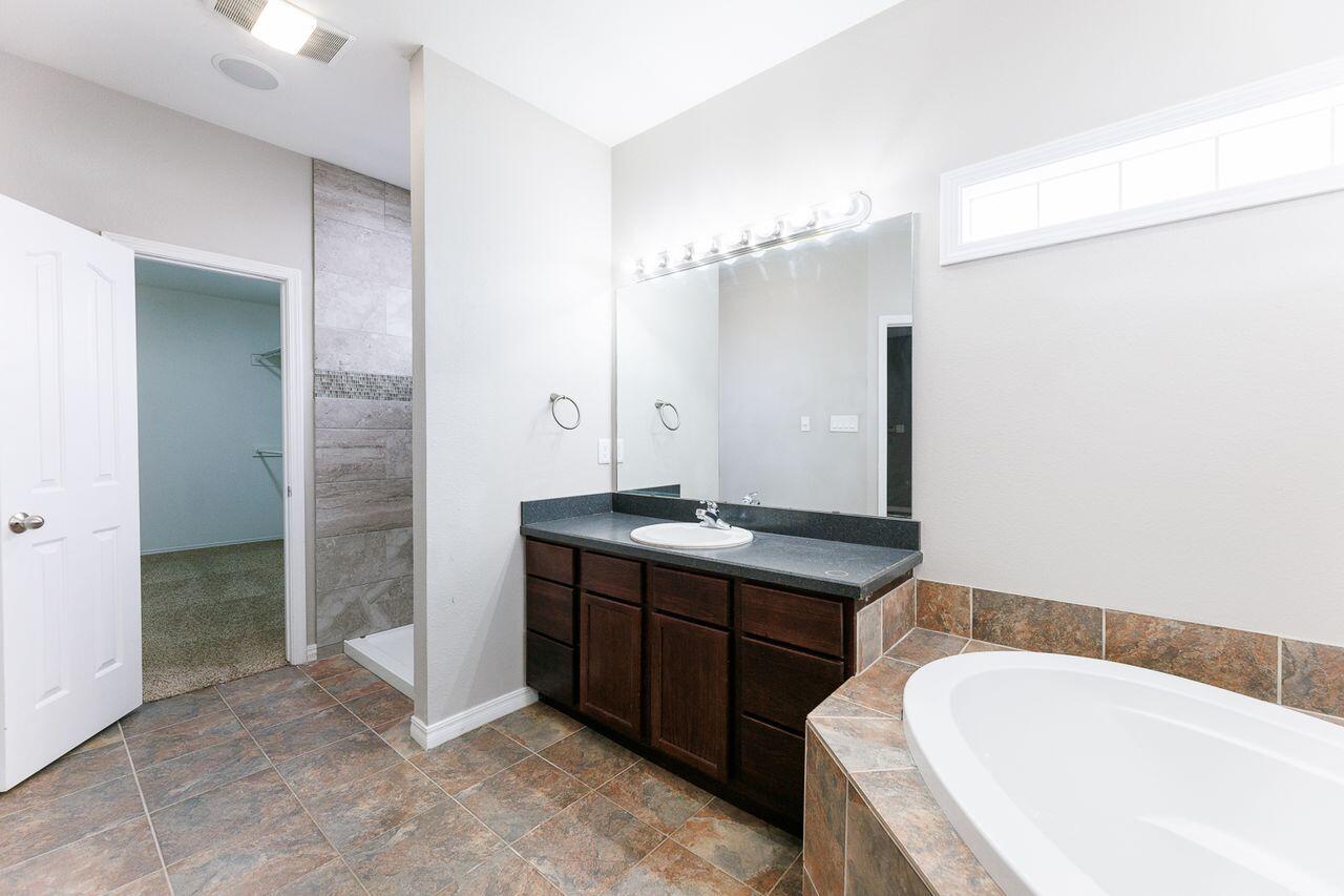 5811 11th Place, Unit 9 Lubbock, TX 79416 - Photo 39 of 50 a bathroom with a tub sink and mirror