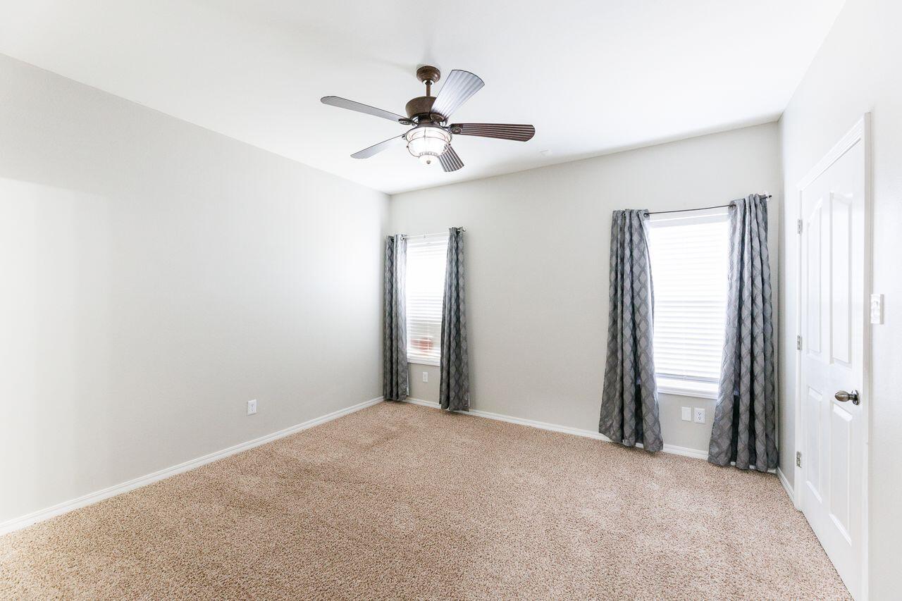 5811 11th Place, Unit 9 Lubbock, TX 79416 - Photo 45 of 50 a view of a room with a ceiling fan and a window
