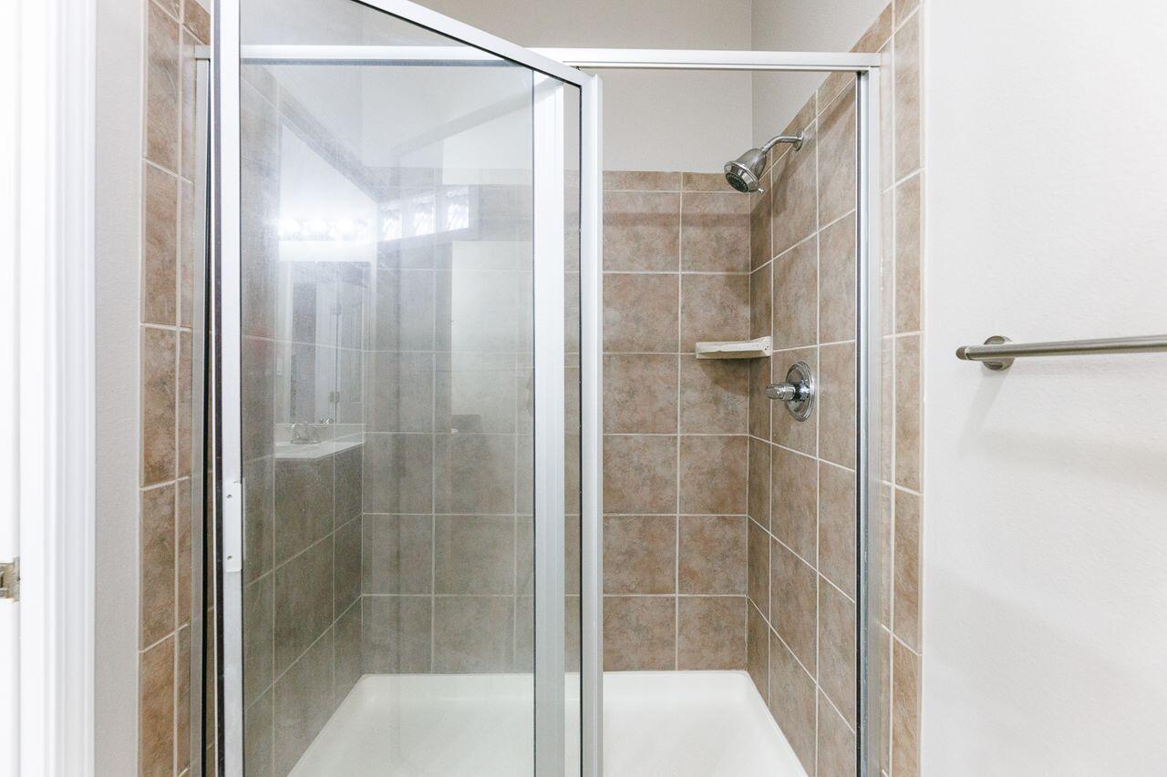 5811 11th Place, Unit 9 Lubbock, TX 79416 - Photo 47 of 50 a bathroom with a glass shower door