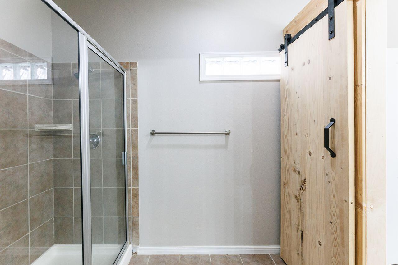 5811 11th Place, Unit 9 Lubbock, TX 79416 - Photo 48 of 50 a bathroom with a glass shower door