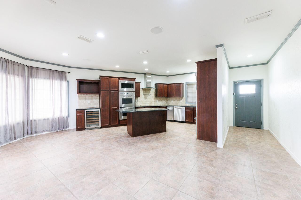 5811 11th Place, Unit 9 Lubbock, TX 79416 - Photo 7 of 50 a large kitchen with stainless steel appliances kitchen island a large counter top and oven