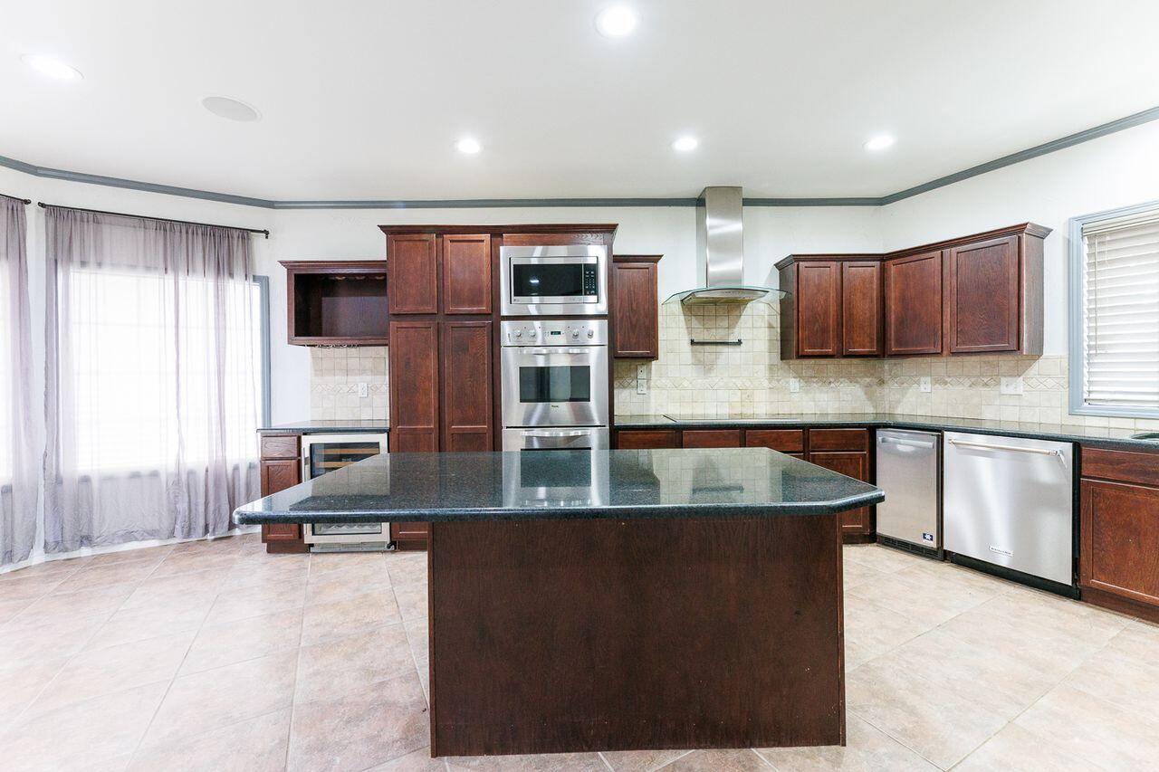 5811 11th Place, Unit 9 Lubbock, TX 79416 - Photo 10 of 50 a kitchen with stainless steel appliances granite countertop a sink and a refrigerator
