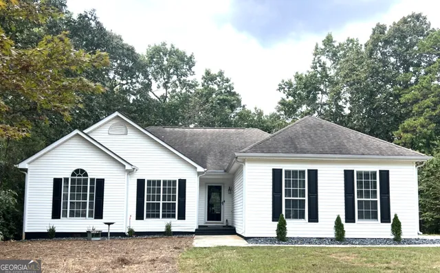 a view of a house with a yard and large tree
