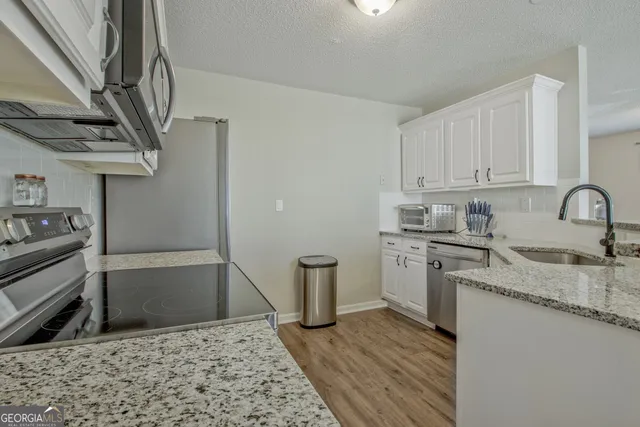 a kitchen with a sink appliances and cabinets