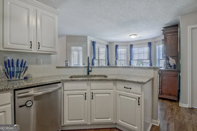 a kitchen with granite countertop a sink and cabinets
