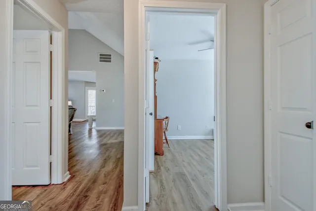 a view of a hallway with wooden floor and closet area