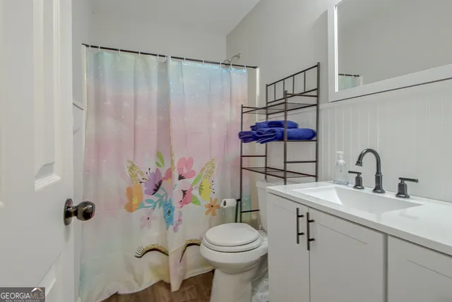 a bathroom with a sink toilet and shower