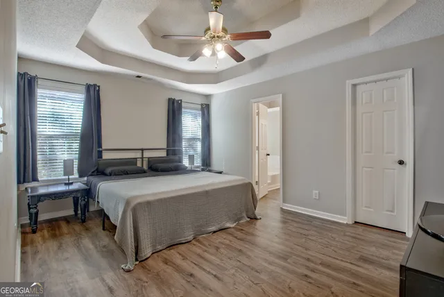 a bedroom with a large bed a chandelier and a window