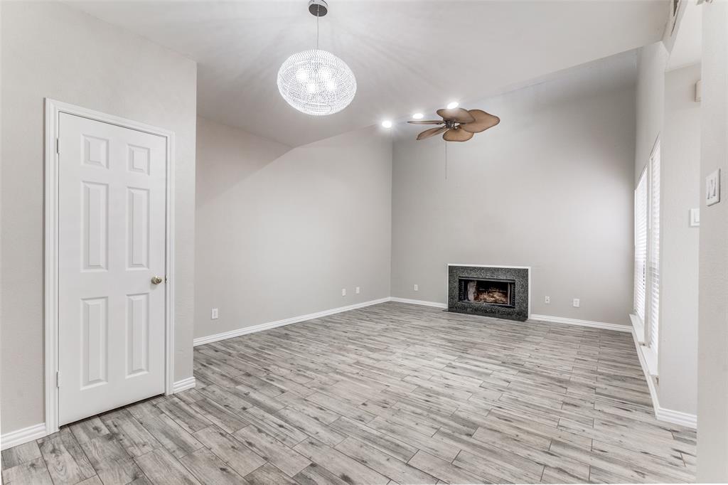 an empty room with wooden floor ceiling fan