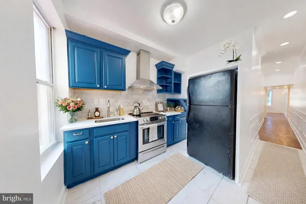 a kitchen with stainless steel appliances granite countertop a refrigerator and a sink