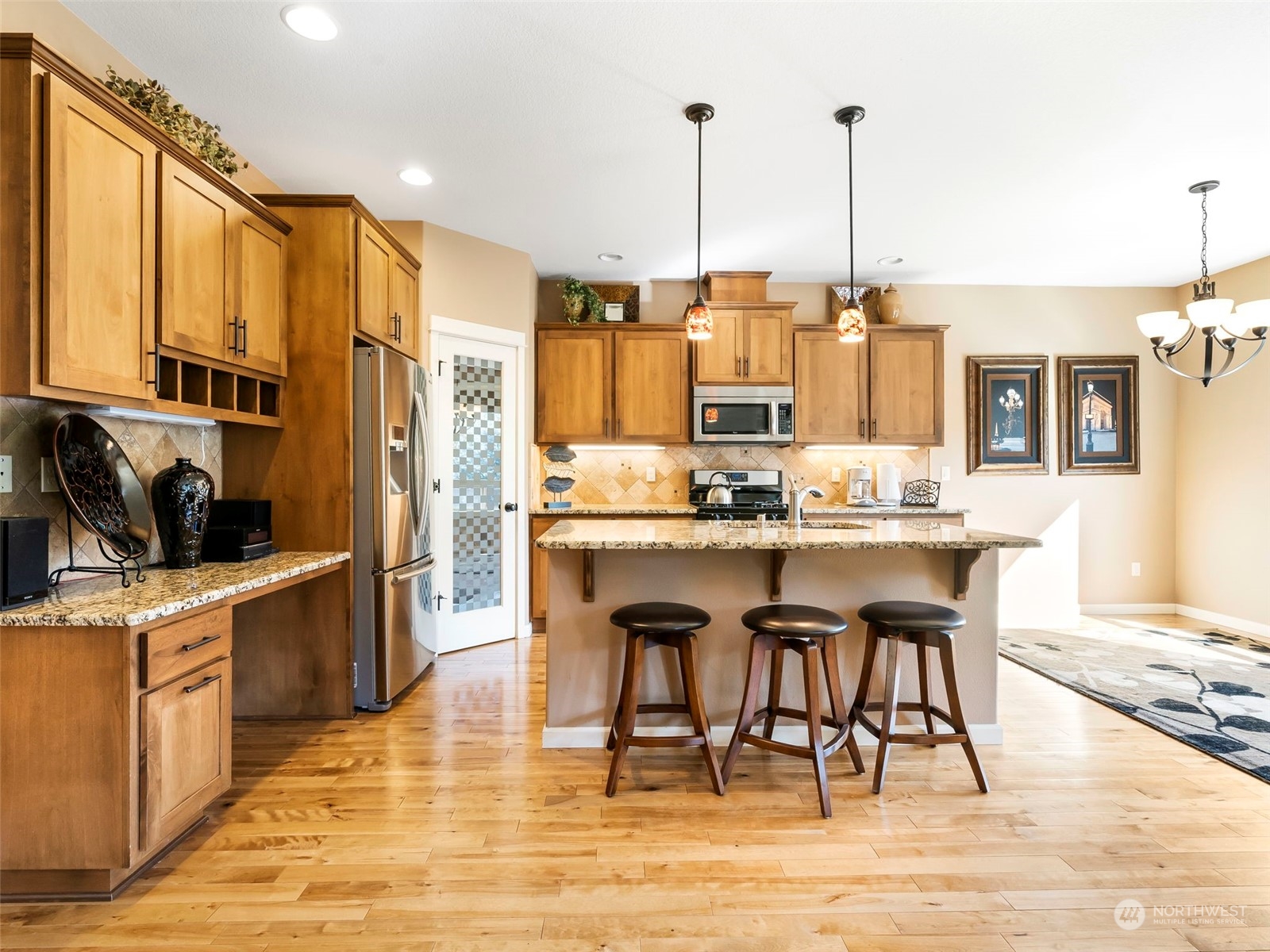 17005 Northeast 33rd Avenue Ridgefield, WA 98642 - Photo 5 of 38 a kitchen with stainless steel appliances kitchen island granite countertop a table chairs and a stove