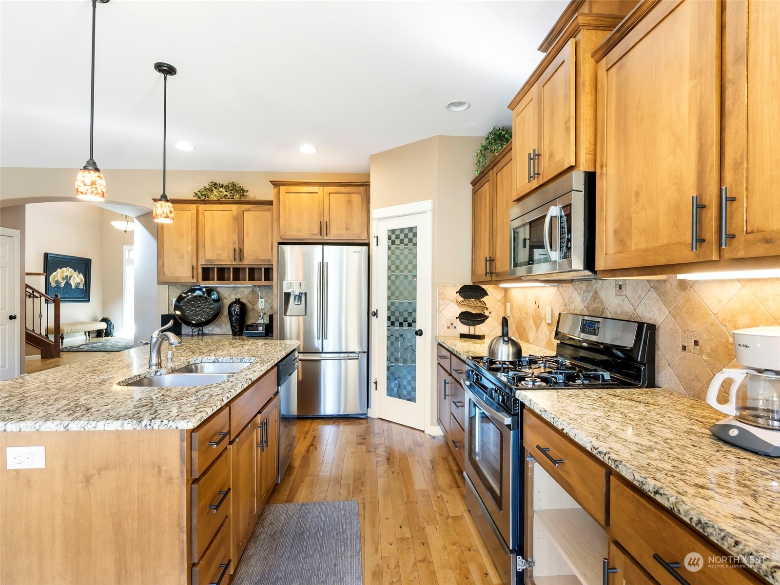 17005 Northeast 33rd Avenue Ridgefield, WA 98642 - Photo 6 of 38 a kitchen with stainless steel appliances granite countertop a sink a stove and a wooden floors