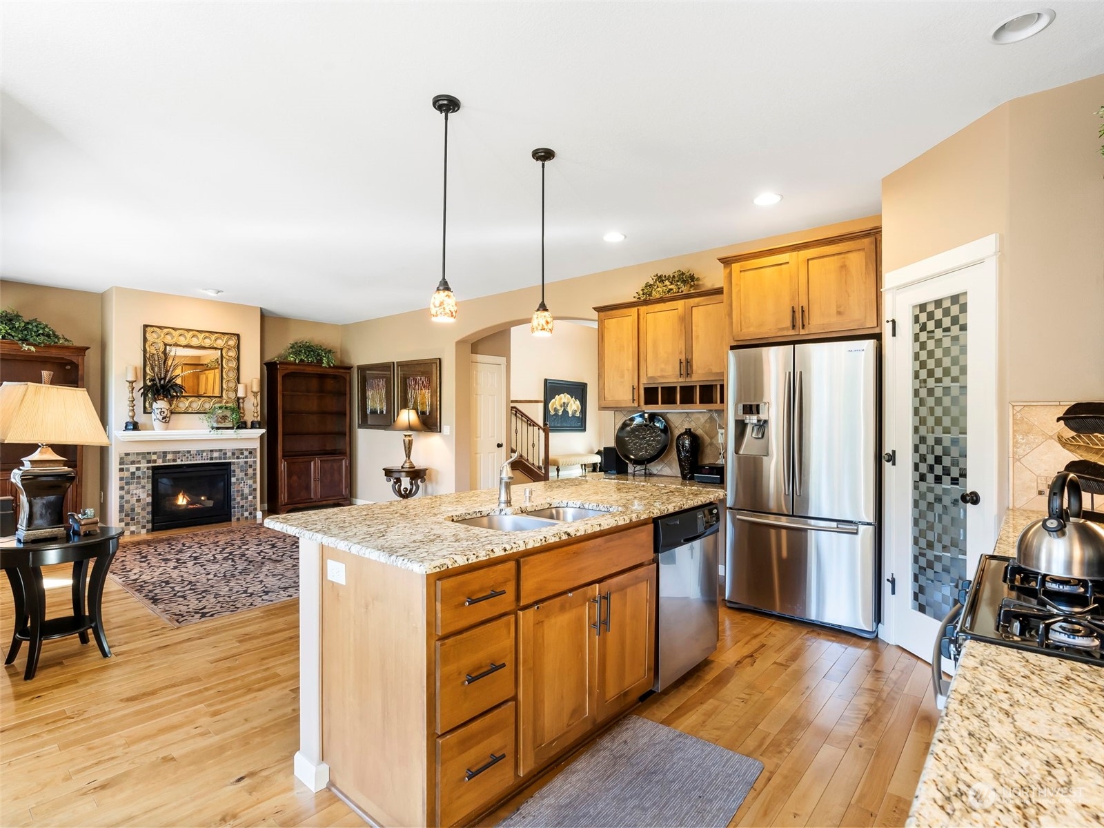 17005 Northeast 33rd Avenue Ridgefield, WA 98642 - Photo 7 of 38 a kitchen with stainless steel appliances granite countertop a refrigerator a sink dishwasher a oven with a dining table and chairs with wooden floor