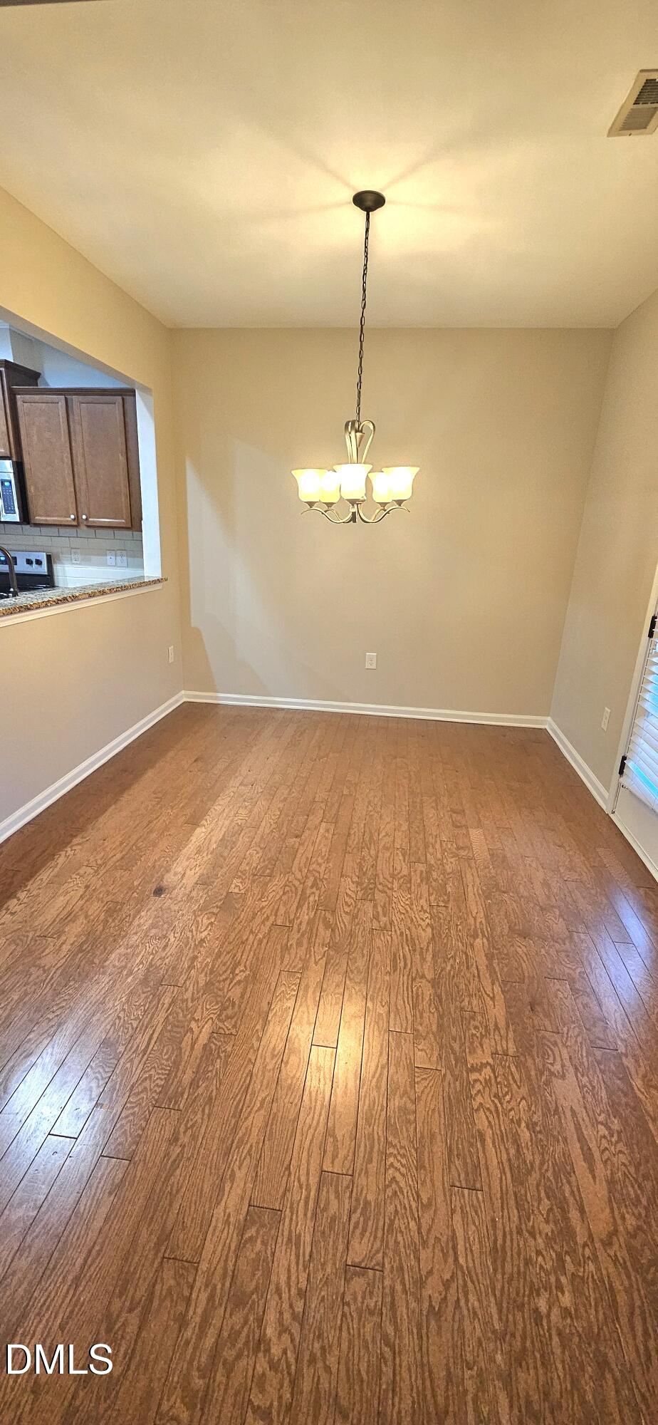313 Brier Crossings Loop Durham, NC 27703 - Photo 10 of 27 a view of an empty room with wooden floor and a window