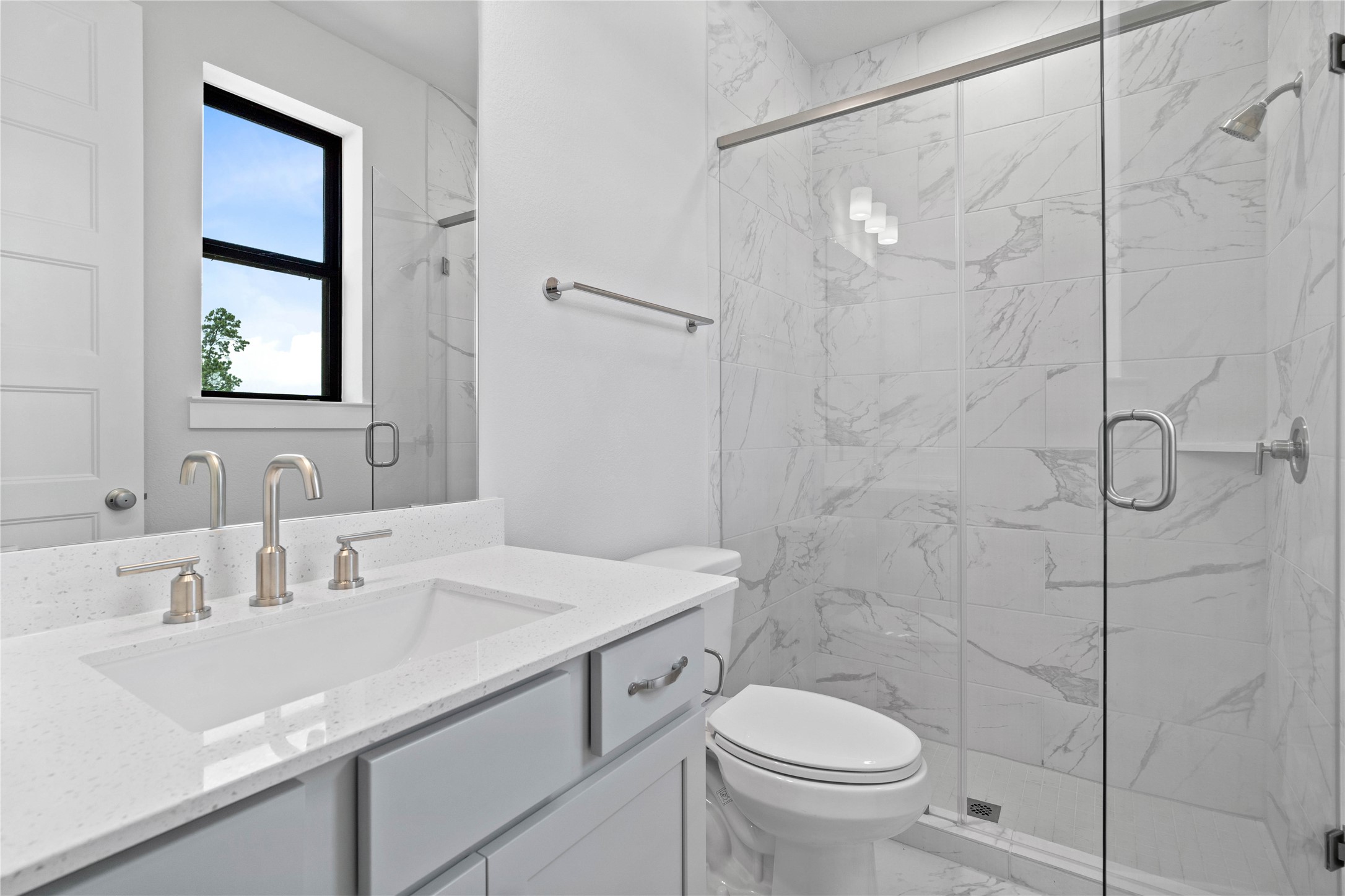 551 Black Bronco Road Magnolia, TX 77354 - Photo 12 of 50 The private en suite bathroom features a modern vanity with light countertop, and a walk-in shower with sleek tile surround.