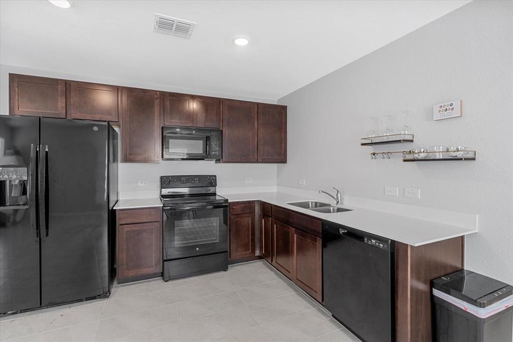 8730 Texas Risinger Drive Fort Worth, TX 76123 - Photo 12 of 19 a kitchen with stainless steel appliances a sink stove and refrigerator