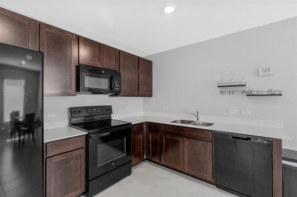 8730 Texas Risinger Drive Fort Worth, TX 76123 - Photo 16 of 19 a kitchen with a sink and stainless steel appliances