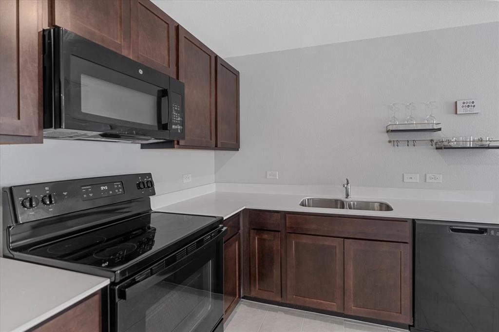 8730 Texas Risinger Drive Fort Worth, TX 76123 - Photo 17 of 19 a kitchen with a sink stove and microwave