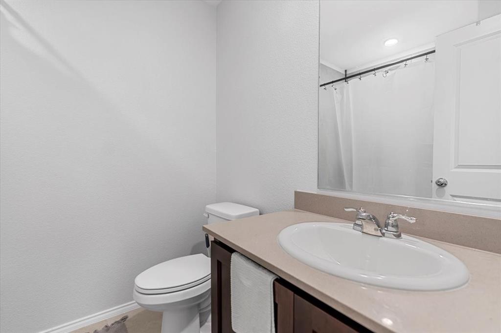 8730 Texas Risinger Drive Fort Worth, TX 76123 - Photo 4 of 19 a bathroom with a sink toilet and a mirror