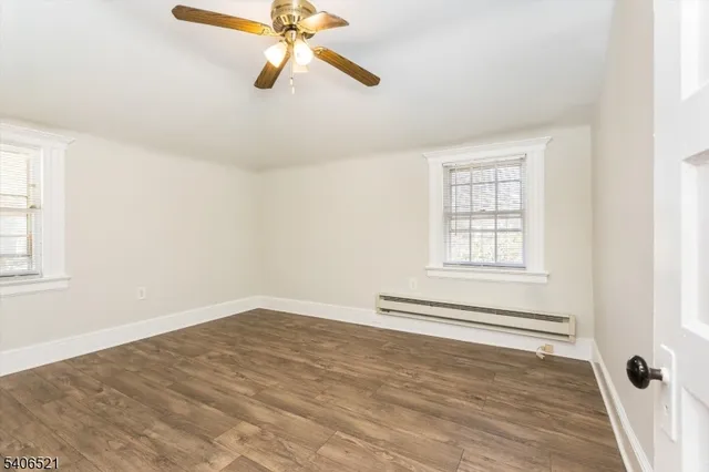 an empty room with windows and fan