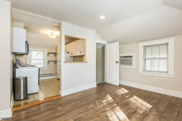 a view of a kitchen with wooden floor and a refrigerator