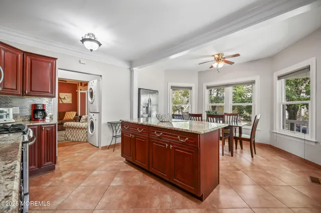 a view of kitchen with stainless steel appliances granite countertop dining room