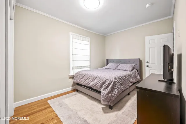 a spacious bedroom with a bed and wooden floor