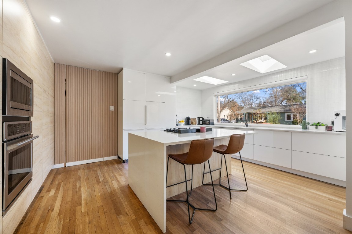1403 Palo Duro Road Austin, TX 78757 - Photo 10 of 34 a kitchen with stainless steel appliances kitchen island hardwood floor sink and stove