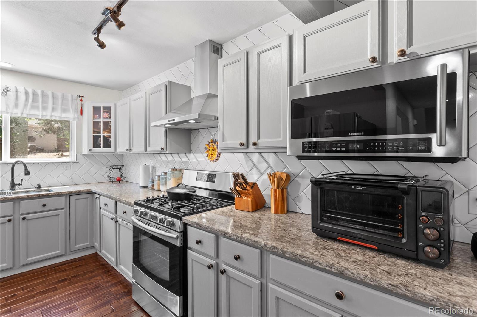 2212 Hyacinth Road Littleton, CO 80129 - Photo 16 of 44 a kitchen with stainless steel appliances granite countertop a stove and a microwave