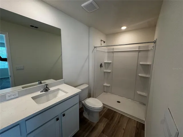 a bathroom with a sink a toilet and shower