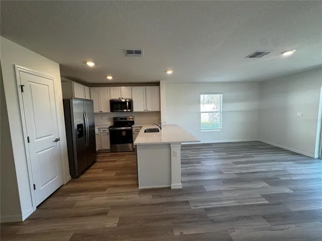 a view of kitchen with refrigerator microwave and cabinets