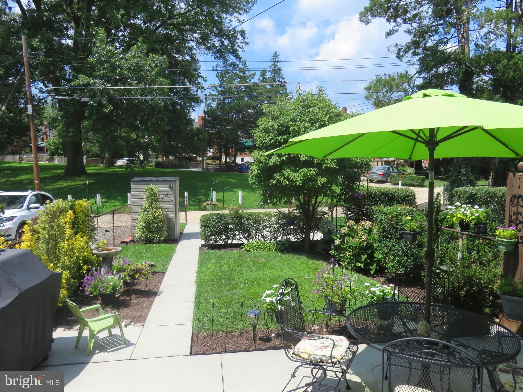 8428 Pleasant Plains Road Baltimore, MD 21286 - Photo 26 of 29 a view of a garden with chairs and an umbrella