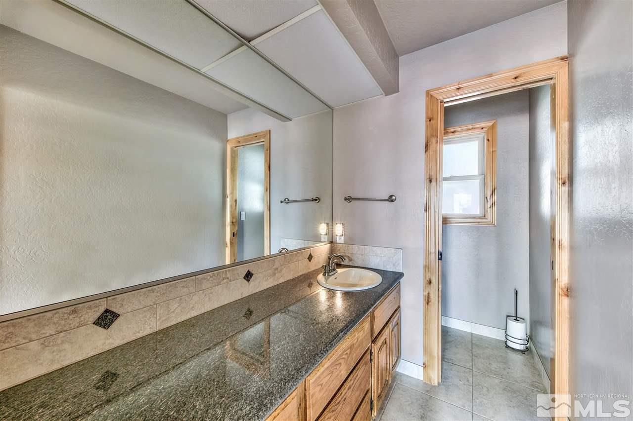 218 Terrace View Drive Stateline, NV 89449 - Photo 17 of 22 a bathroom with a granite countertop sink and a mirror