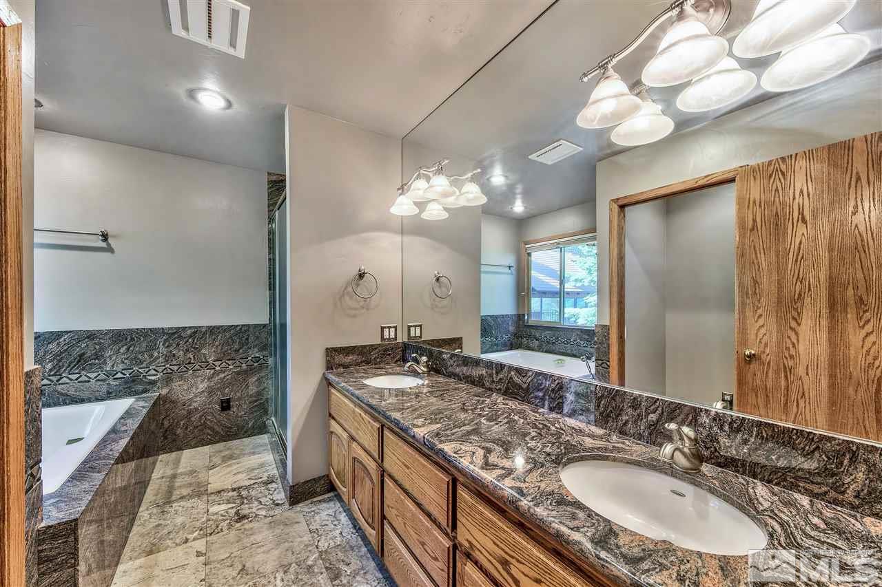 218 Terrace View Drive Stateline, NV 89449 - Photo 10 of 22 a bathroom with a granite countertop sink a large mirror and a shower