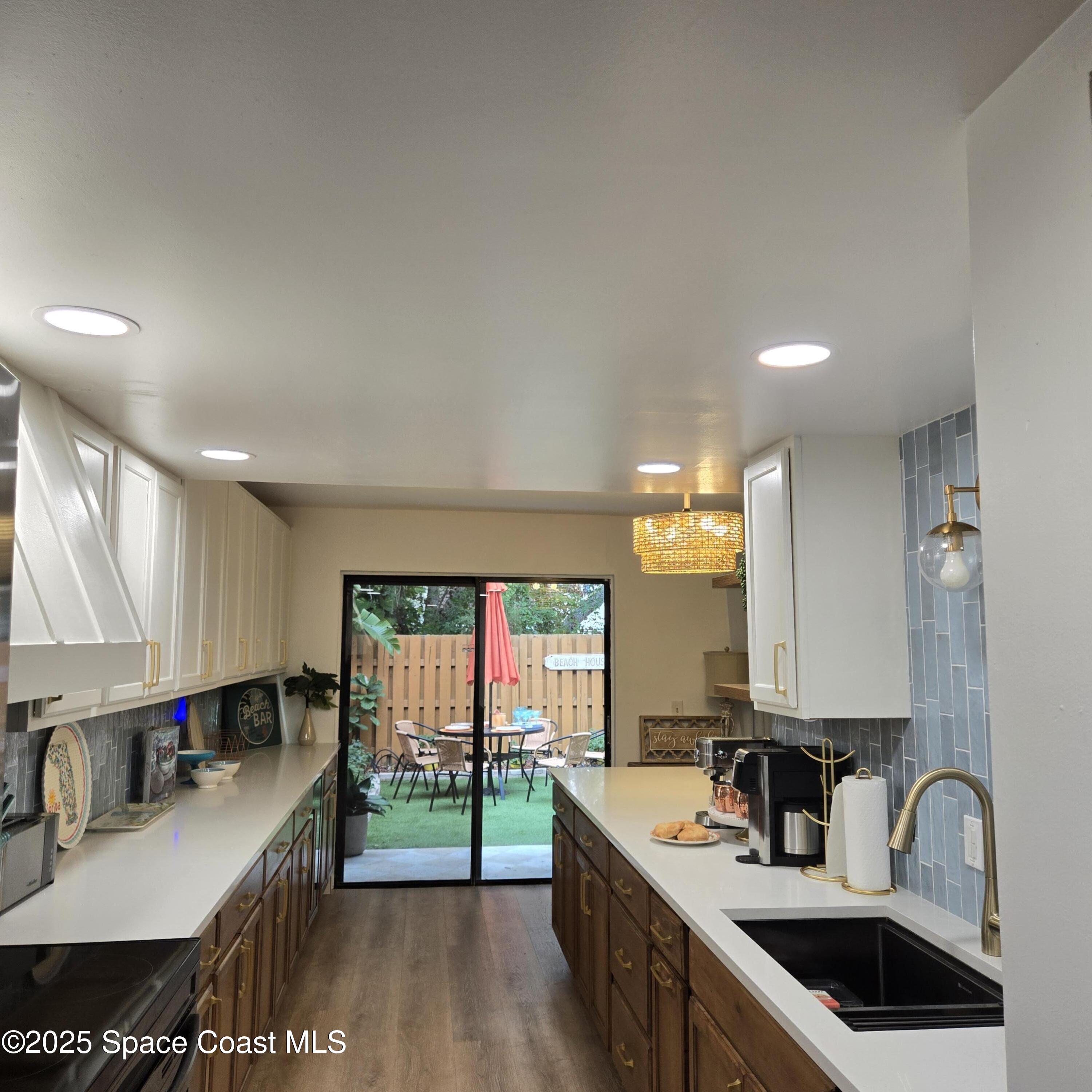 8761 Ilex Court Cape Canaveral, FL 32920 - Photo 13 of 41 a kitchen with kitchen island granite countertop a sink stove and cabinets