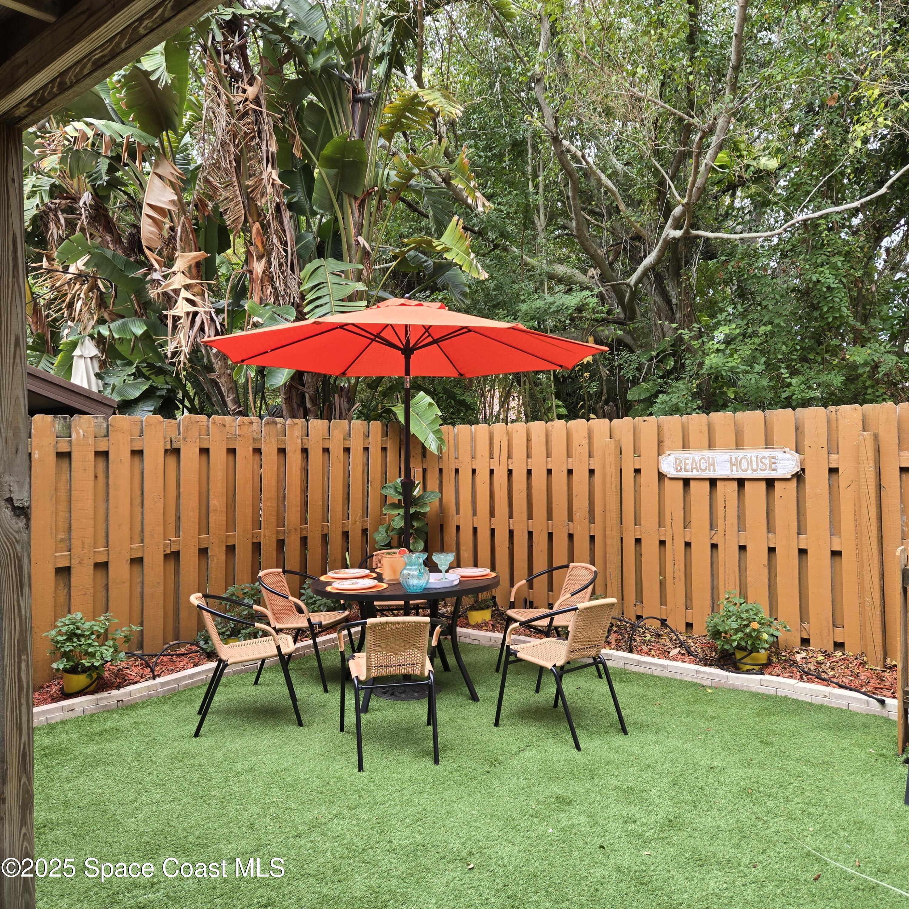 8761 Ilex Court Cape Canaveral, FL 32920 - Photo 15 of 41 a view of a backyard with a table and chairs