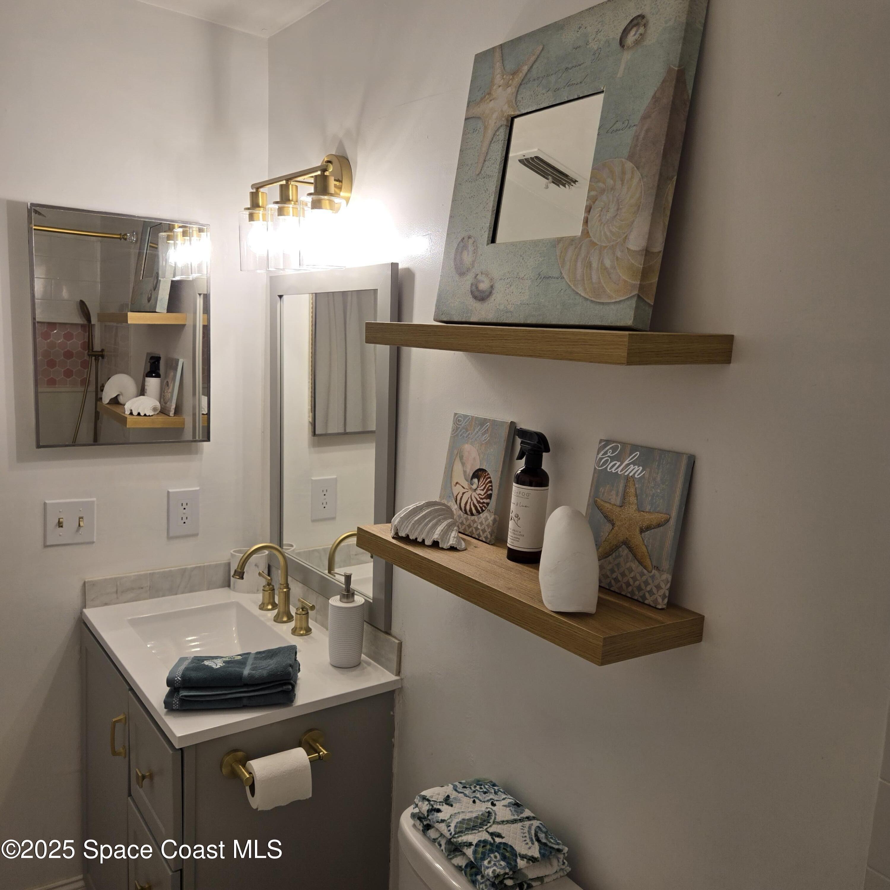 8761 Ilex Court Cape Canaveral, FL 32920 - Photo 20 of 41 a bathroom with a sink and a mirror