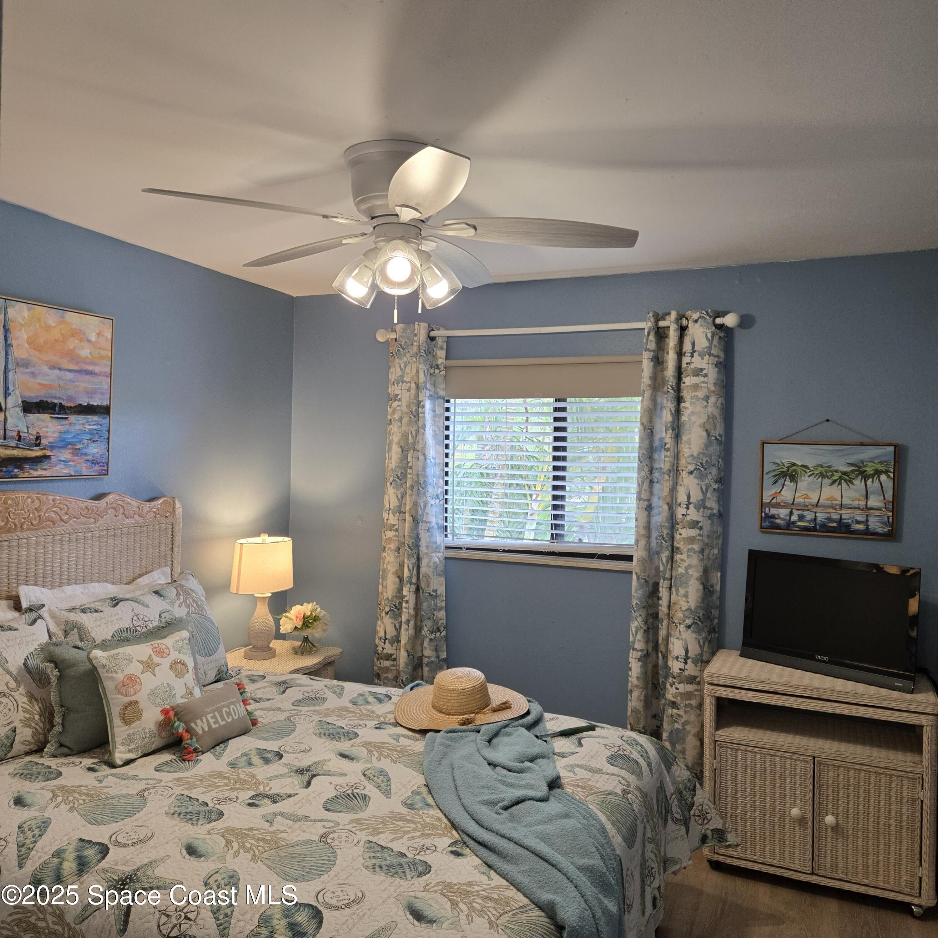 8761 Ilex Court Cape Canaveral, FL 32920 - Photo 23 of 41 a bedroom with a bed and a flat screen tv