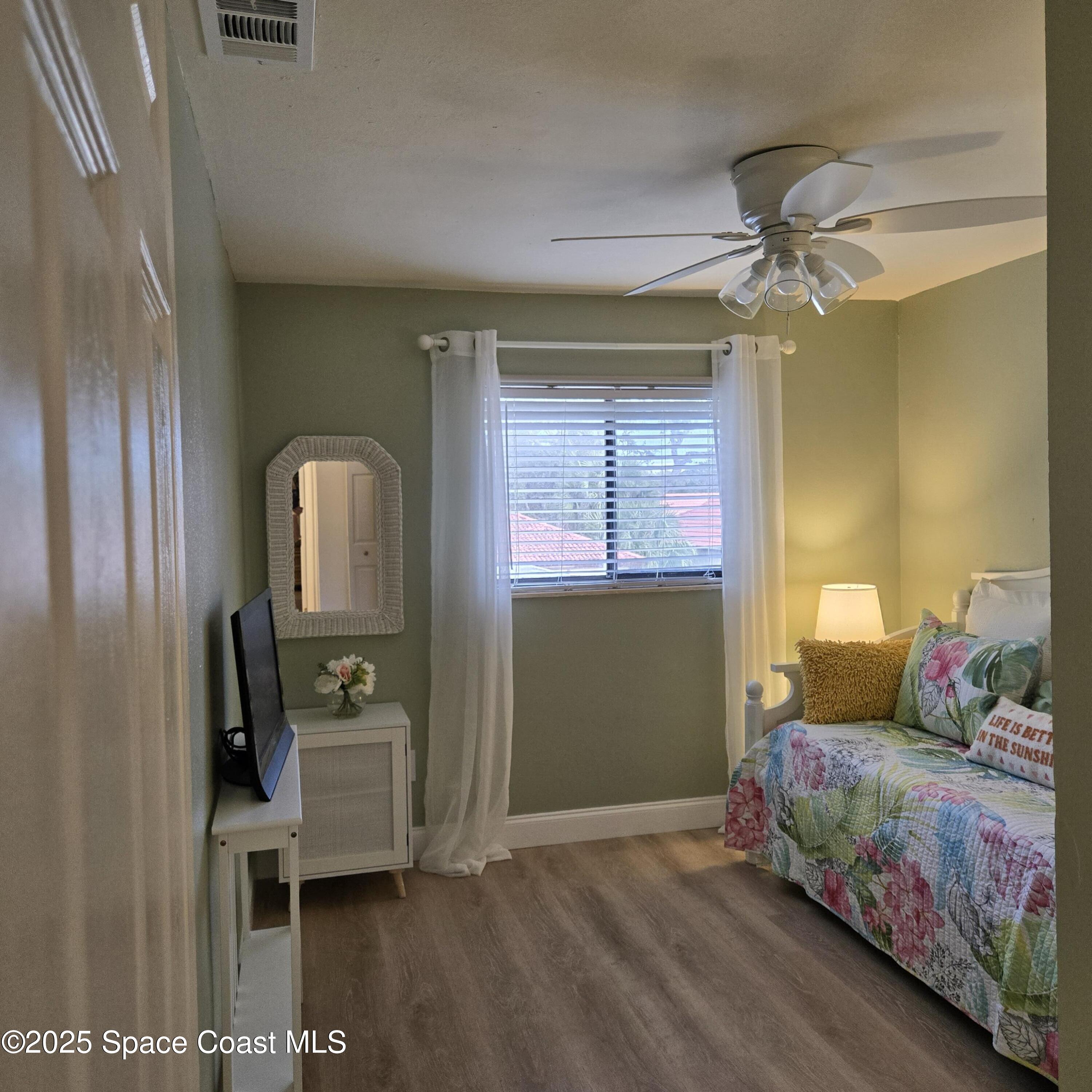 8761 Ilex Court Cape Canaveral, FL 32920 - Photo 27 of 41 a bedroom with a bed and wooden floor