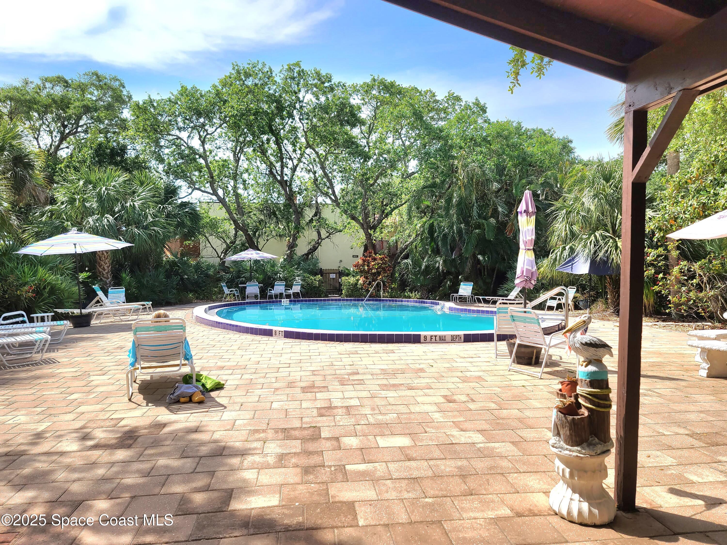 8761 Ilex Court Cape Canaveral, FL 32920 - Photo 31 of 41 a view of a swimming pool with a patio