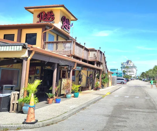 a group of people sitting under an umbrella in front of retail shop