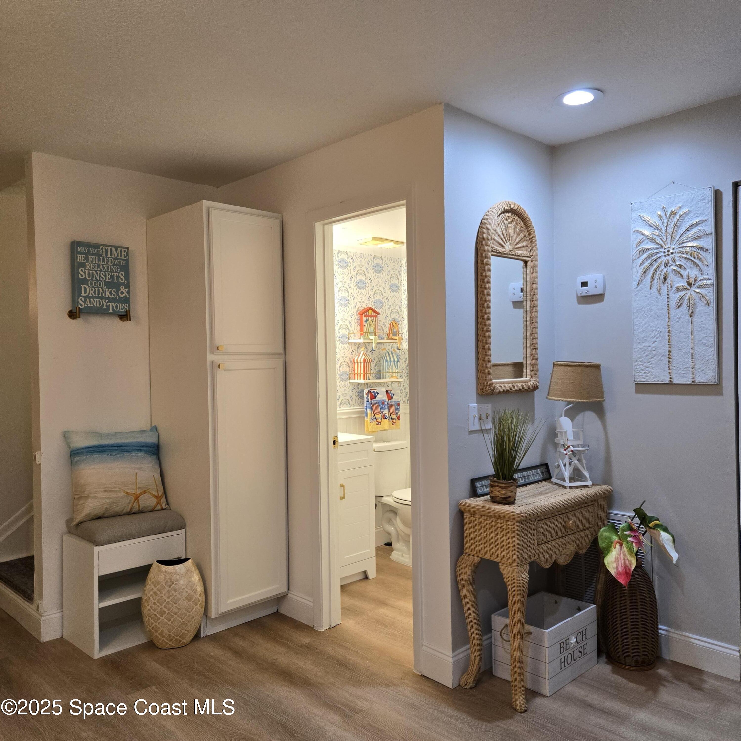 8761 Ilex Court Cape Canaveral, FL 32920 - Photo 4 of 41 a hallway with furniture and a potted plant