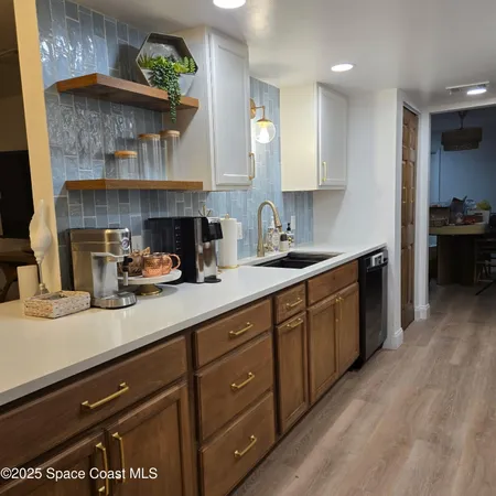 a kitchen with stainless steel appliances granite countertop a stove a sink a refrigerator and a wooden cabinets