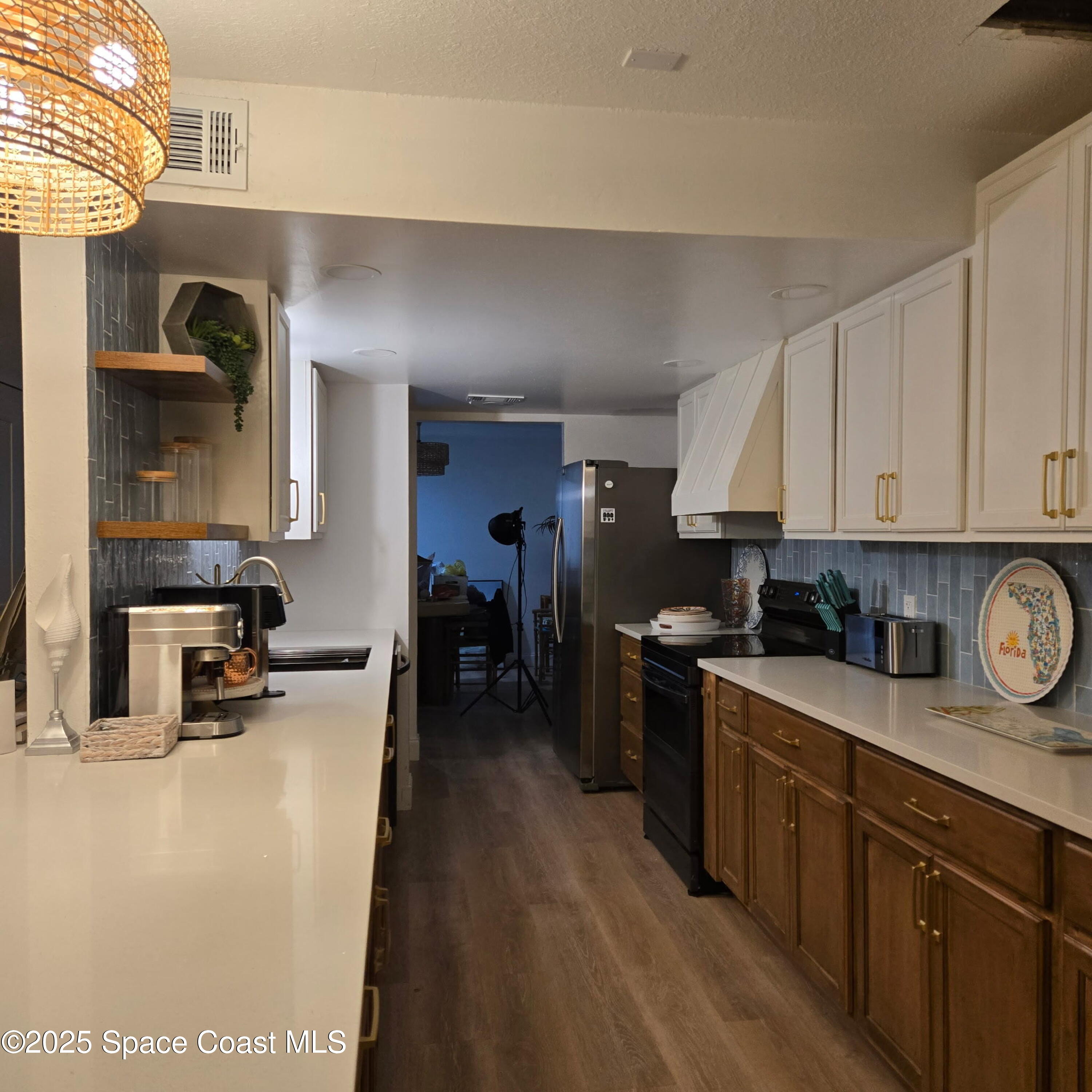 8761 Ilex Court Cape Canaveral, FL 32920 - Photo 9 of 41 a kitchen with stainless steel appliances granite countertop a stove a sink a refrigerator and a wooden cabinets