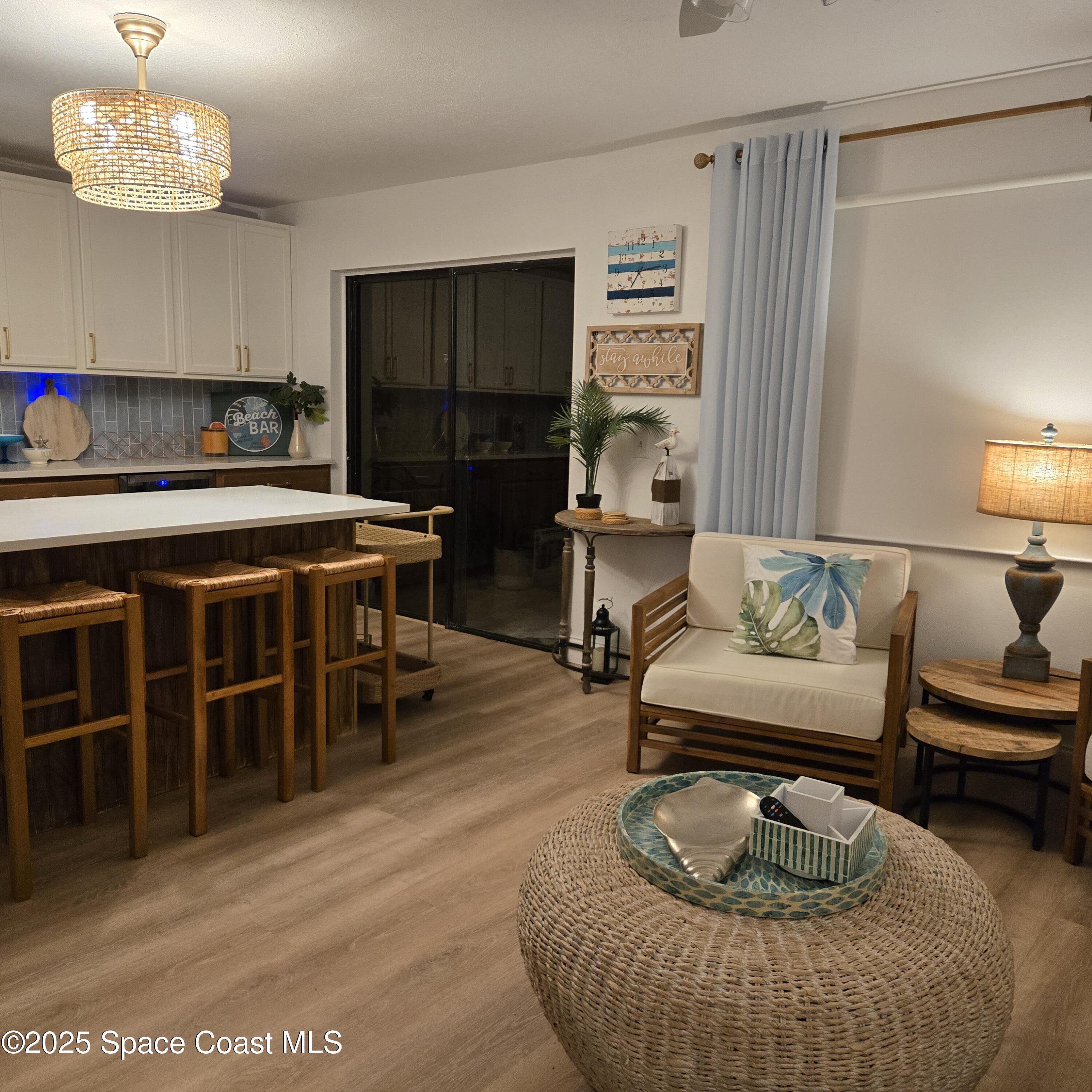 8761 Ilex Court Cape Canaveral, FL 32920 - Photo 10 of 41 a living room with furniture a lamp and a dining table