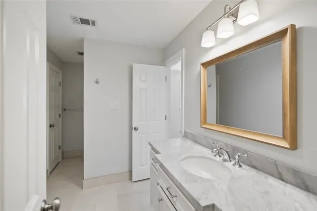 a bathroom with a granite countertop double vanity sink and a mirror