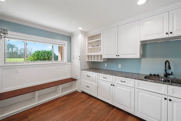 a kitchen with granite countertop white cabinets and a window