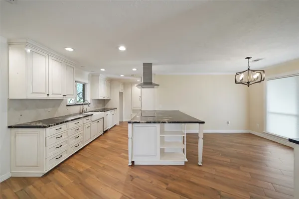 a kitchen with granite countertop a stove and a wooden floors