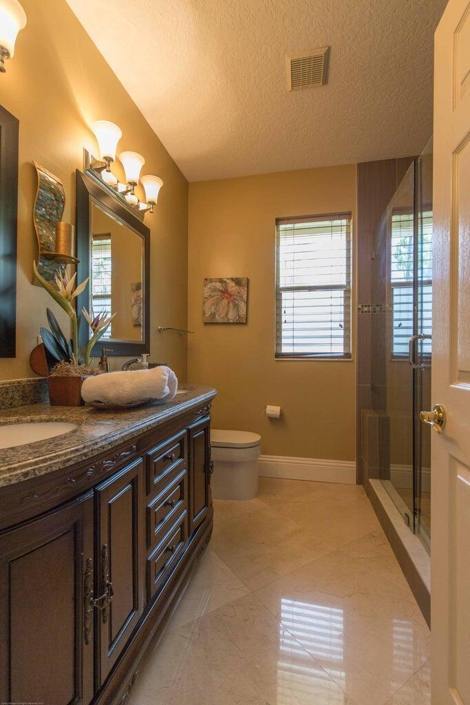 14816 Stirrup Lane Wellington, FL 33414 - Photo 17 of 30 a spacious bathroom with a granite countertop sink a toilet and a tub