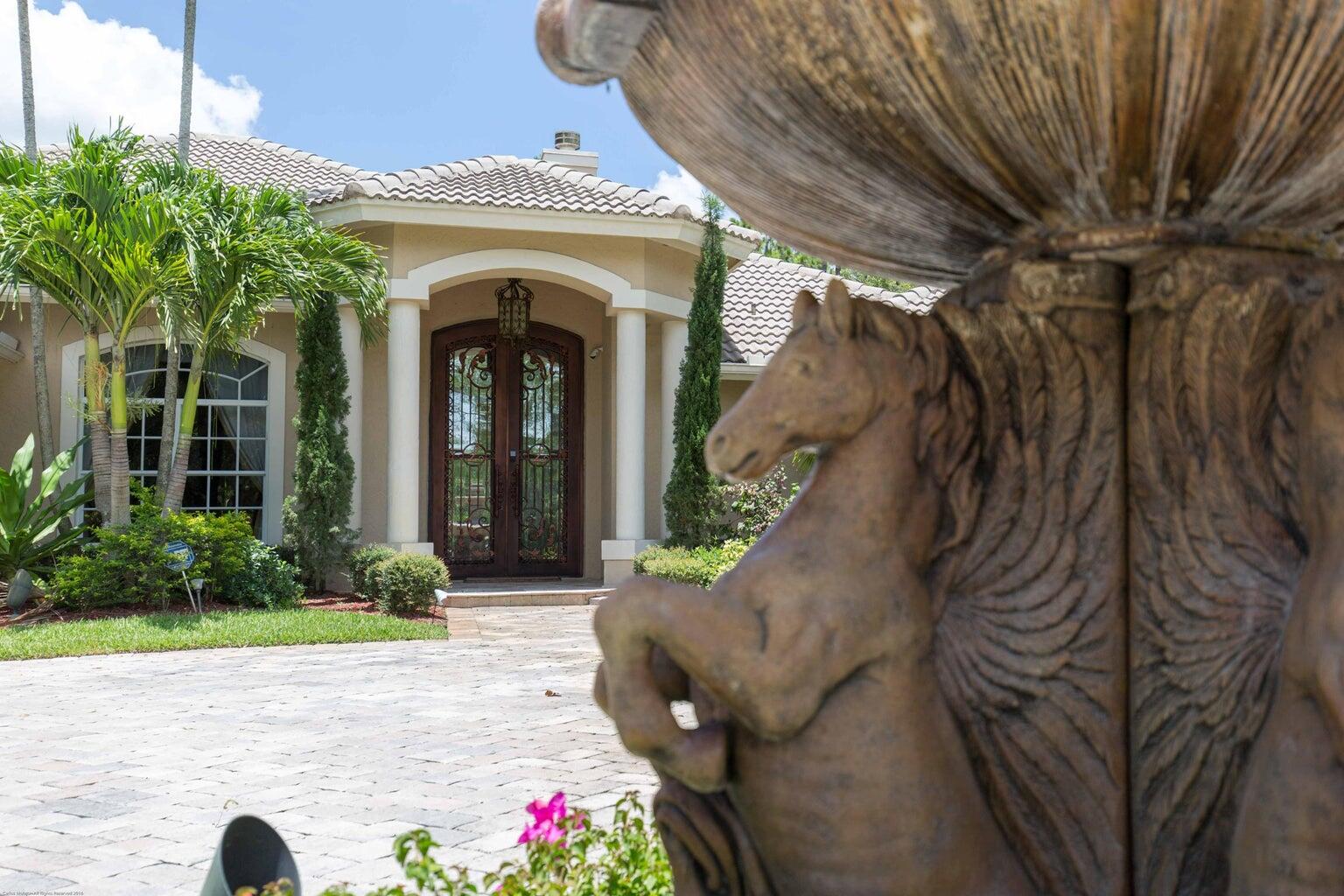 14816 Stirrup Lane Wellington, FL 33414 - Photo 2 of 30 a front view of a house with garden